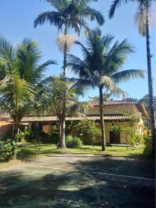 a group of palm trees in front of a building at Casa Praia Jardim Acapulco in Guarujá