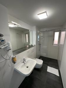 a white bathroom with a sink and a toilet at NorthWest Apartments in Hamburg