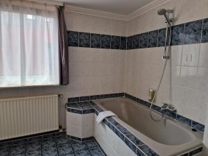 H5 Hotel Bremen في بريمين: حمام مع حوض استحمام ودش