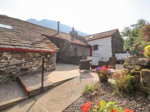a stone house with a patio and a yard at The Hayloft in Keswick