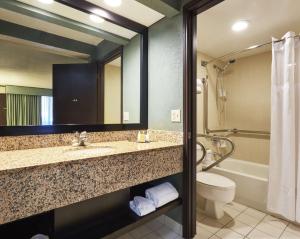 a bathroom with a sink and a toilet and a tub at DoubleTree by Hilton Orlando Theme Park Resort in Orlando +91 photos