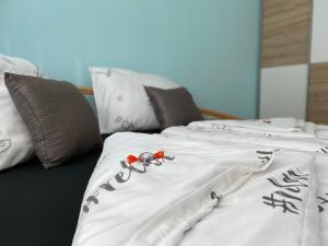 two beds with white comforters and scissors on them at Haus 77 in Hollabrunn