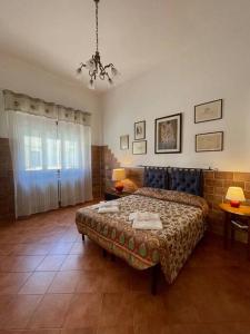 ein Schlafzimmer mit einem Bett, zwei Tischen und einem Fenster in der Unterkunft Viareggio ampia casa con giardino in Viareggio