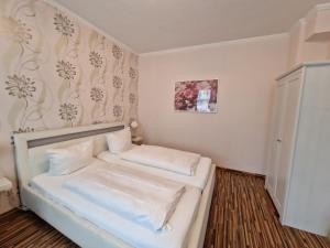 Habitación pequeña con cama con sábanas blancas. en H5 Hotel Bremen, en Bremen