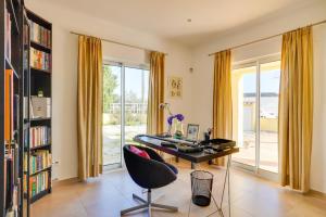 a home office with a desk and a chair at Pôr-do-sol Villa in São Pedro do Corval