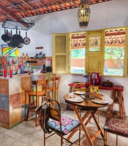 eine Küche mit einem Tisch, Stühlen und einer Theke in der Unterkunft Sítio SPA Céu De Verdade , Praia de Barra Nova , Ceará in Cascavel