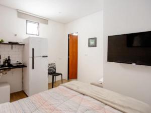a bedroom with a bed and a tv on a wall at CykelHaus Studios in Sao Paulo
