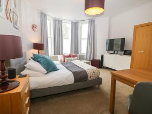 a bedroom with a bed and a desk and a television at Y Castell Apartment 1 in Criccieth
