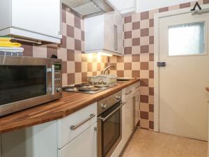 a kitchen with a sink and a microwave at Y Castell Apartment 1 in Criccieth