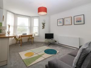 uma sala de estar com um sofá e uma mesa em Y Castell Apartment 2 em Porthmadog