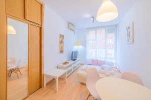 sala de estar con sofá blanco y TV en For You Rentals Bonito y cómodo estudio cerca al Barrio Tetuán M (ARA1) en Madrid