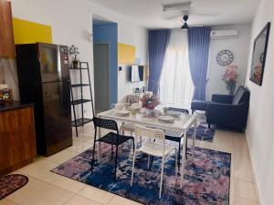 cocina y sala de estar con mesa blanca y sillas en AF Homestay 15mins to KLIA FREE WIFI NETFLIX, en Sepang