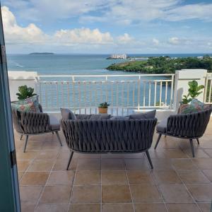 a balcony with a table and chairs and the ocean at Boricua Realty VIP Luxury Ocean Front Penthouse 3 Bedrooms 3 Bathrooms 2 Levels in Fajardo