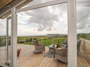 a patio with a view of the countryside through a glass door at Cae'r Wylan in Pwllheli
