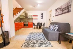 Una sala de estar con un sofá y una cocina. en La casa di Lù, en Trieste