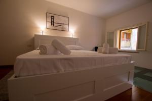 Un dormitorio con una gran cama blanca con dos almohadas. en La casa di Lù, en Trieste 2 fotos más