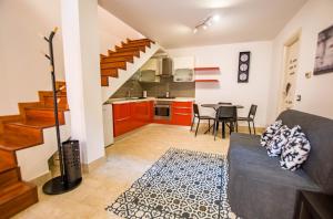 Una sala de estar con un sofá y una mesa y una cocina. en La casa di Lù, en Trieste