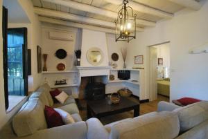 una sala de estar con sofás y una lámpara de araña. en Finca La Vicaria Alameda, en Zufre