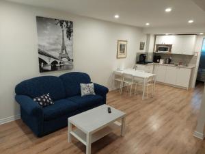 a living room with a blue couch and a table at Spacious basement one bedroom apartment, WiFi. in Montreal