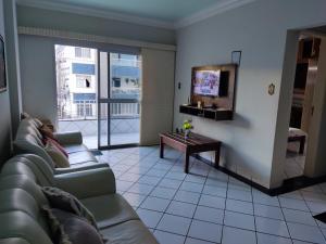 sala de estar con sofá y TV en Edificio Katarina Praia do Morro, en Guarapari