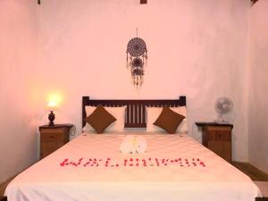 a bedroom with a bed with a valentine sign on it at Rangsot Inn in Pawenang