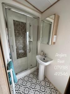 a bathroom with a shower and a sink at Anglers Rest, with Hot Tub and Private Fishing Peg in Tattershall