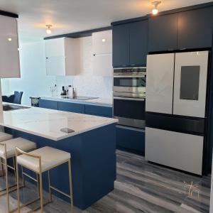 a kitchen with white appliances and blue cabinets at Boricua Realty VIP Luxury Ocean Front Penthouse 3 Bedrooms 3 Bathrooms 2 Levels in Fajardo