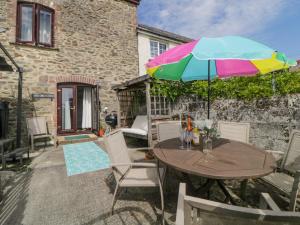 a table and chairs with an umbrella on a patio at The Orchard in Okehampton