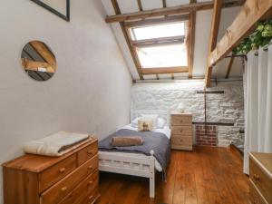 a bedroom with a bed and a dresser and a window at The Orchard in Okehampton