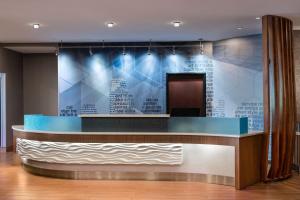 a lobby with a blue wall with writing on it at SpringHill Suites West Mifflin in West Mifflin