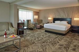 a hotel room with a bed and a living room at Hilton Cincinnati Airport in Florence +39 photos