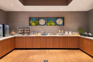 a restaurant with a counter with food on it at SpringHill Suites West Mifflin in West Mifflin