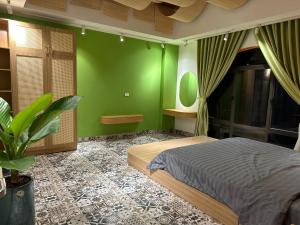 a bedroom with a bed and a green wall at A4 Home - Ha Long city Central in Ha Long