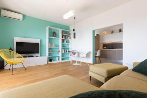 a living room with a couch and a chair and a television at Villa Capra Verde in Ičići