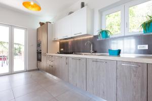 a kitchen with wooden cabinets and a sink and a window at Villa Capra Verde in Ičići
