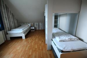 2 camas en una habitación con suelo de madera en Ferienhaus Höller en Grömitz