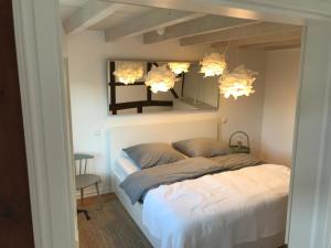 1 dormitorio con cama, espejo y silla en eichHAUS Eifel en Rheinbach