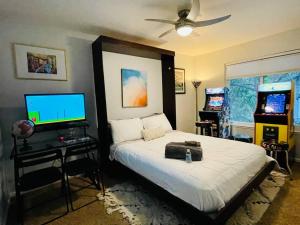 a bedroom with a bed with a television and a bed sidx sidx sidx at Artists Condo GAME ROOM Patio near UC Med Center in Sacramento