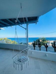 a swing on a balcony with a view of the ocean at Paradiso sul mare in Santa Cesarea Terme