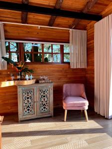 um quarto com uma cadeira e uma parede de madeira em La Perla Finca Hotel em Gigante