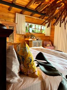 a bedroom with a bed with pillows on it at La Perla Finca Hotel in Gigante