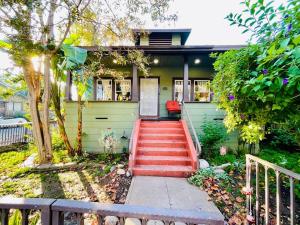 a green house with a red staircase in front of it at Artists Bungalow ARCADE King Beds near the beat in Sacramento