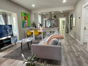 a living room with a gray couch and a kitchen at Artists Bungalow ARCADE King Beds near the beat in Sacramento