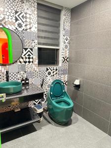 a bathroom with a green toilet and a mirror at A4 Home - Ha Long city Central in Ha Long
