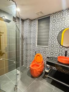 an orange stool in a bathroom with a shower at A4 Home - Ha Long city Central in Ha Long