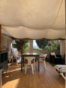 eine Terrasse mit einem Tisch und Stühlen unter einem Zelt in der Unterkunft Les Restanques du Sud in Le Lavandou