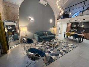 sala de estar con sofá, sillas y mesa en San Giacomo Loft Apartment, en Barletta