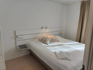 a white bed with a headboard in a room at Aalborg City Rooms ApS in Aalborg