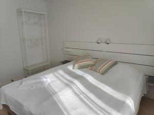 a white bed with two pillows on top of it at Aalborg City Rooms ApS in Aalborg