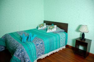 - une chambre avec un lit bleu et des oreillers bleus dans l'établissement HOSTAL SALARCITO, à Uyuni